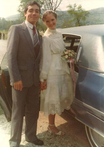 Annie and her husband standing outside on their wedding day.