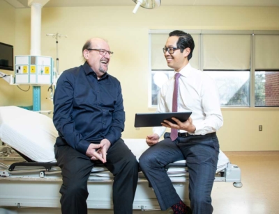 Dan Collins with Oncologist Dr. Michael Ong of The Ottawa Hospital in a patient room.