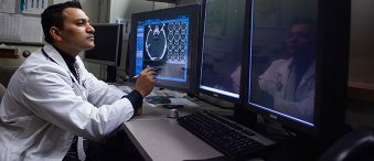 Le Dr Nair examine des images prises par IRM à l’écran.